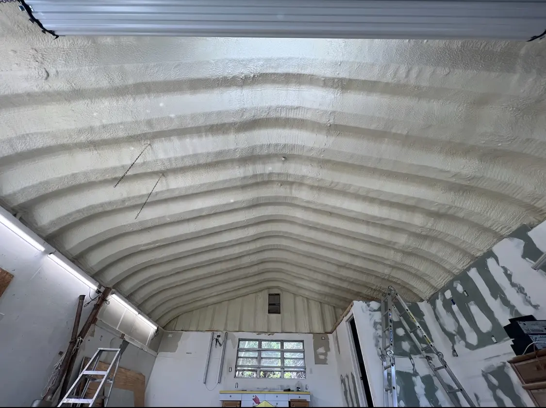 Spray polyurethane foam applied to the underside of a metal roof deck in Central